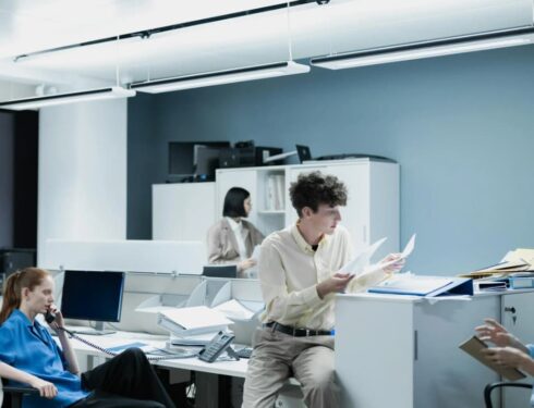 Office workers engaged in various tasks in a brightly lit office environment