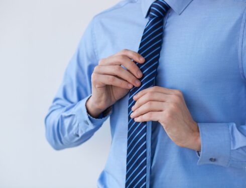 Cropped view of businessman adjusting tie